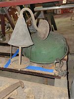 Green enamel pendant shade and metal wall sconce on workbench