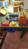 Overview of lot on bench showing Craftsman socket case, blue metal toolbox, Prestone kit, wooden toolbox tote and other items