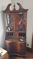 Full view of secretary desk with bookcase top, showing drawers, glass doors, bonnet
