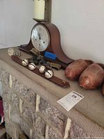Mantel clock, glass knobs, bell strap and wooden shoe lasts displayed on stone mantel