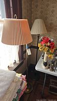 Both floor lamps beside window and table