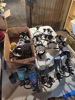 Overview showing box of assorted candle hardware and two large wrought iron candelabra frames