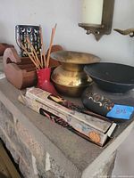 Group view on mantle showing lantern, bowls, boot vase, incense box