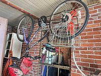 Full view of bicycle hanging upside down showing frame, wheels and attached handlebar bag