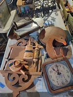 Overview of lot showing Elgin clock face, duck plaque, wrought iron candelabra, wooden kitchen pieces and scrollwork plaque