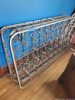 Pair of metal coil box springs leaning against wall