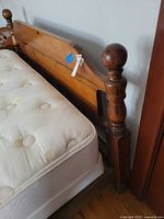 Overall view of solid wood queen headboard attached to bed frame