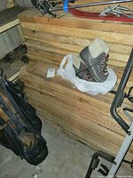 Side view of stacked rough sawn planks with boots on top