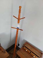 Full view of solid wood coat rack showing overall form and base