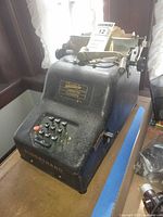 Front angled view showing full adding machine with keypad and paper carriage