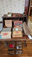 Overall view showing cigar boxes, souvenir spoons, pipes, mesh bag