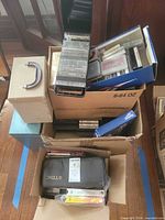 Stacked boxes containing VHS tapes, cassettes, vinyl singles, index card file