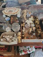 Overview of all items: angel figurines, ornaments, nativity pieces, plate, glassware