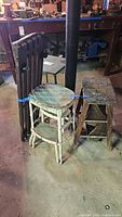 Front view of assorted stools, step stool, folding rack