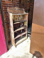 Full view of bookshelf front showing four shelves and distressed paint
