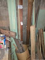 Stack of painted trim, raw boards and stained strips leaning against wall