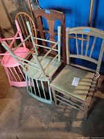 Group of five assorted wooden chairs showing different colors and styles