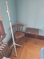 All three items grouped: white coat rack, brown spindle-back chair, brown folding TV tray