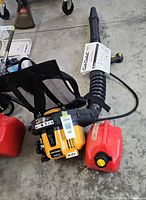 Overall view of blower with manual and fuel can attached