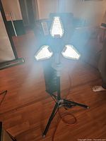 Work light illuminated showing three lit panels on tripod
