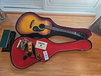 Guitar in open case with accessories and foot rest visible