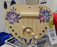 Full front view of heart-shaped door harp with floral painting and strings