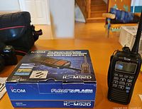 Radio standing next to retail box on table