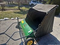 Side view showing full sweeper, tow bar, wheels, hopper