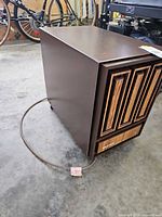 Right side and front view of brown Kenmore dehumidifier with attached cord on garage floor