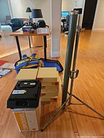 Projector, screen on tripod, four tray boxes stacked