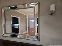 Full view of rectangular mirror on wall showing beveled frame and bead trim