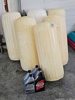 Overall lot view with six fenders standing upright behind three oil bottles