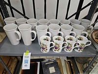 Shelf with 6 tall white mugs, 8 standard white mugs, and 4 berry-pattern mugs