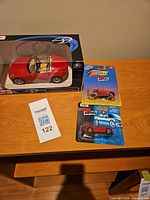 Overall lot showing boxed 1:24 Maisto Pontiac Solstice and blister-card 1:64 Fresh Metal convertible