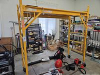 Full view of assembled yellow Metaltech 6-ft scaffold with platform and casters