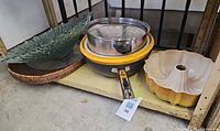 All items arranged together showing glass bowl, wicker tray, stacked cookware and bundt pan