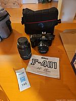 Camera body with kit lens, telephoto lens, bag, manual, filter ring visible