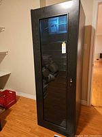 Full exterior view of black Nuvo wine cooler cabinet with glass door.