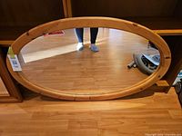 Front view of oval mirror displaying frame and glass