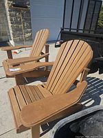 Pair of brown wood Adirondack chairs on driveway