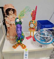 Group view of doll, two bird sculptures and Perplexus ball