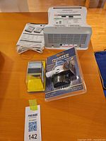 Lot overview showing battery charger, bilge pump package, voltmeter package, cable and manual