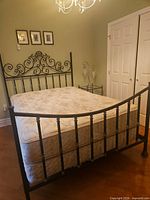 Full view of assembled metal bed frame with mattress and box spring