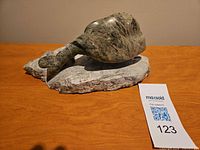 Left side view of soapstone goose sculpture on stone base