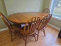 Dining table with leaf inserted and four chairs around it