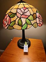 Full view of lamp on table with stained glass shade lit