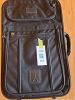 Front view of Travelpro black softside suitcase showing overall design, pockets, handle and wheels