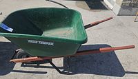 Side view of True Temper wheelbarrow showing green tray and wood handles