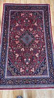 Full view of entire Qom rug on hardwood floor