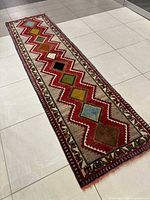Full view of Shiraz wool runner rug on tiled floor